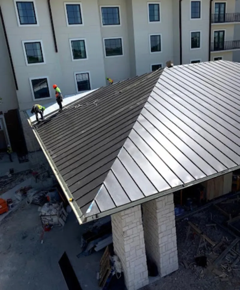 Crew installing standing seam metal roof panels on a commercial project in Canal Winchester